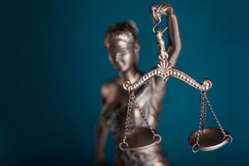 Lady Justice statue scales blindfold blue background