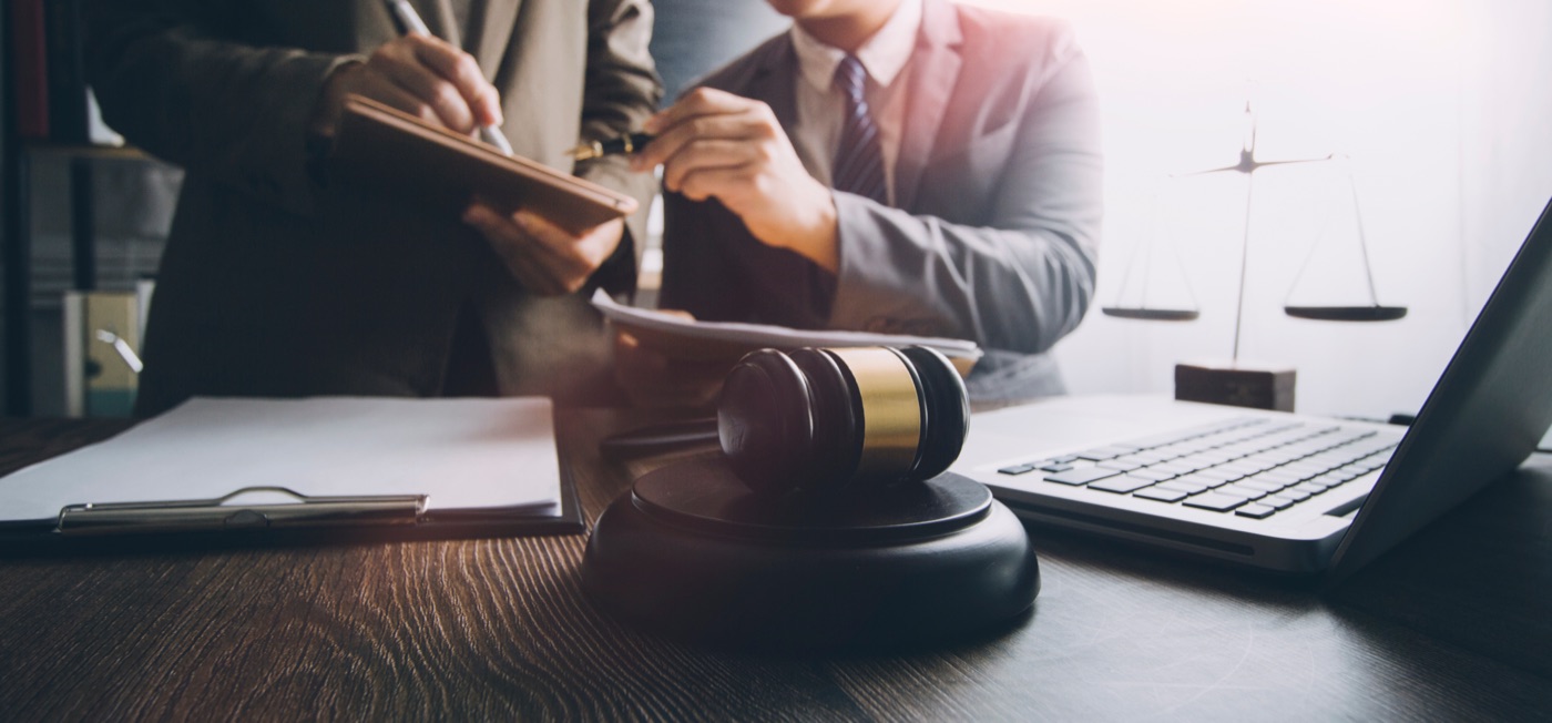 Two men suits gavel desk laptop scales