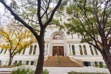 Classical-stone-facade arched-entrance stone-staircase framing-trees