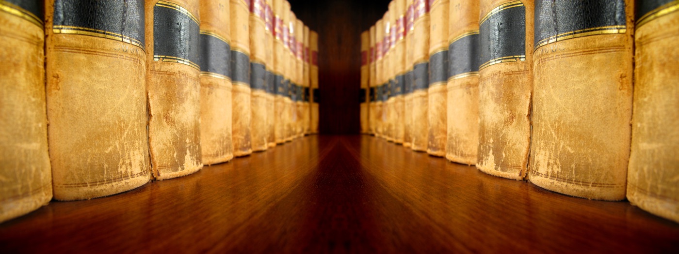 Rows of law books leather spines reflective wood floor vanishing perspective