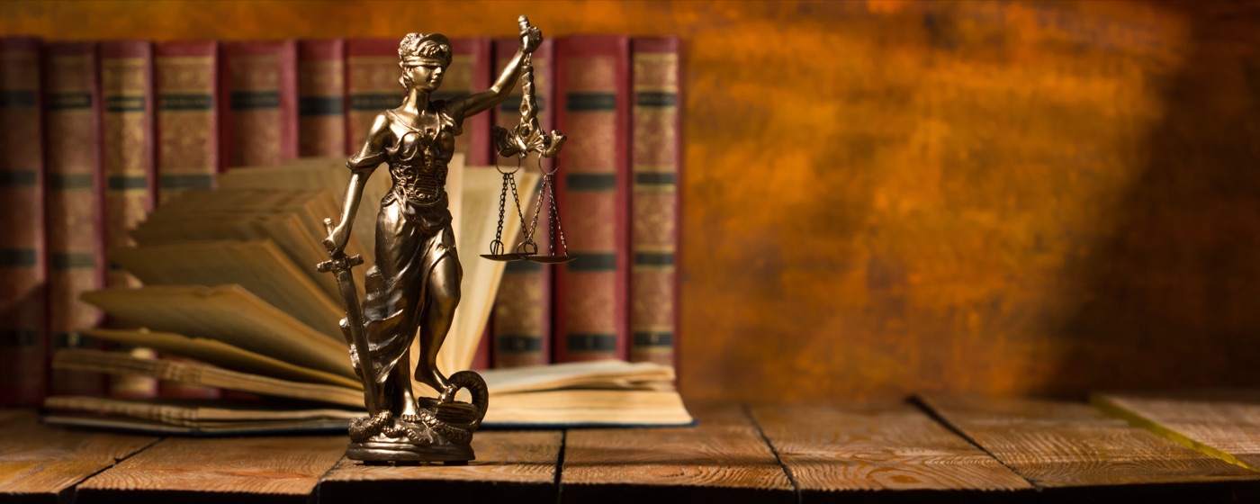 Bronze Lady Justice scales open book warm wood desk